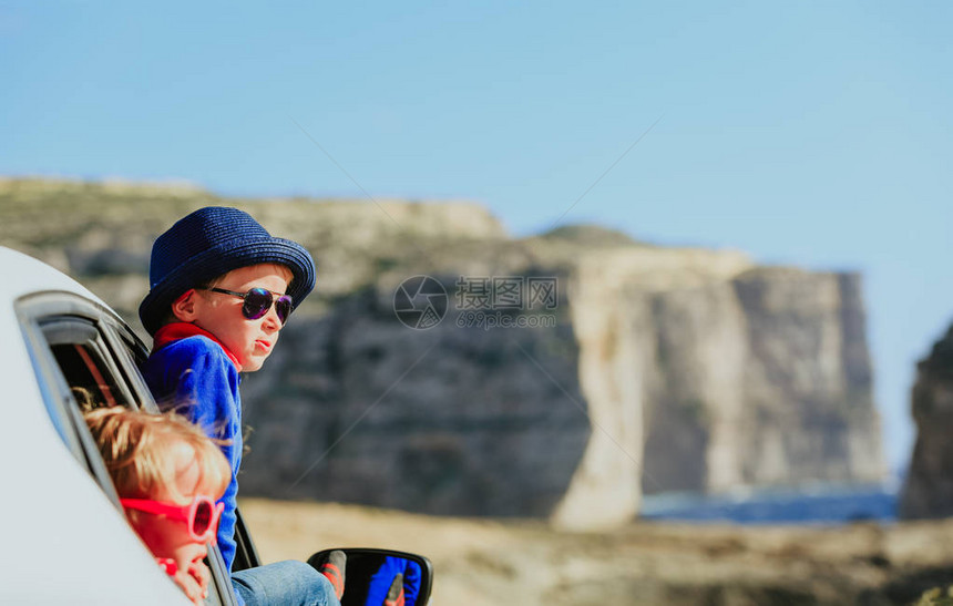 快乐的小男孩女在山上乘车旅行图片