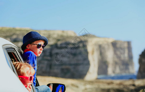 快乐的小男孩女在山上乘车旅行图片
