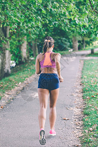 在热带公园跑的赛车运动员妇女健身慢跑运动健康的概念图片