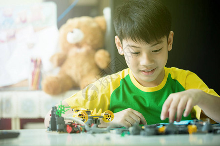 可爱的亚洲男孩玩塑料积木背景图片