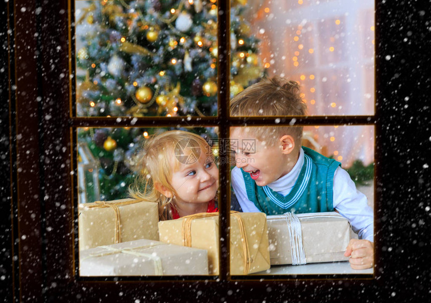 孩子们在装饰的客厅里打开圣诞礼物图片