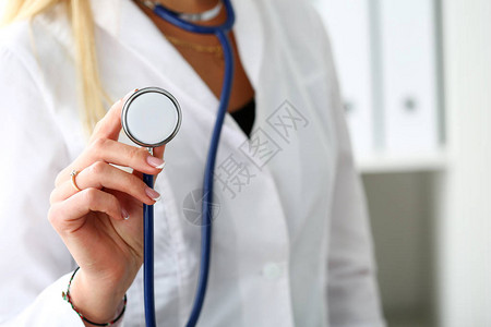 女医生手拿着听诊器头特写在她的胸前医疗商店或商店身体和疾病预防呃顾问911脉搏测量健康背景图片