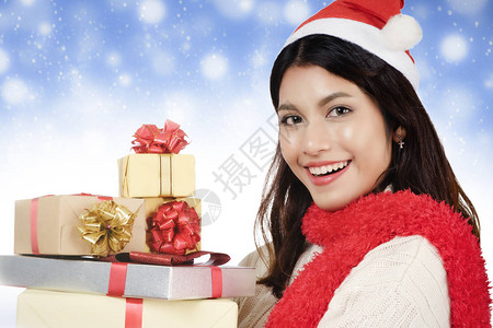 购物理念拿着很多礼物盒蓝色冬天雪背景的妇女圣诞节新年假期庆祝活动和快图片