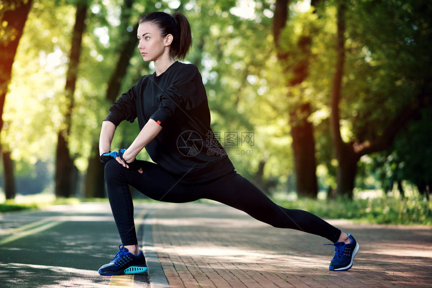 有吸引力和坚强的女人在夏季公园健身前伸展体育概念健图片
