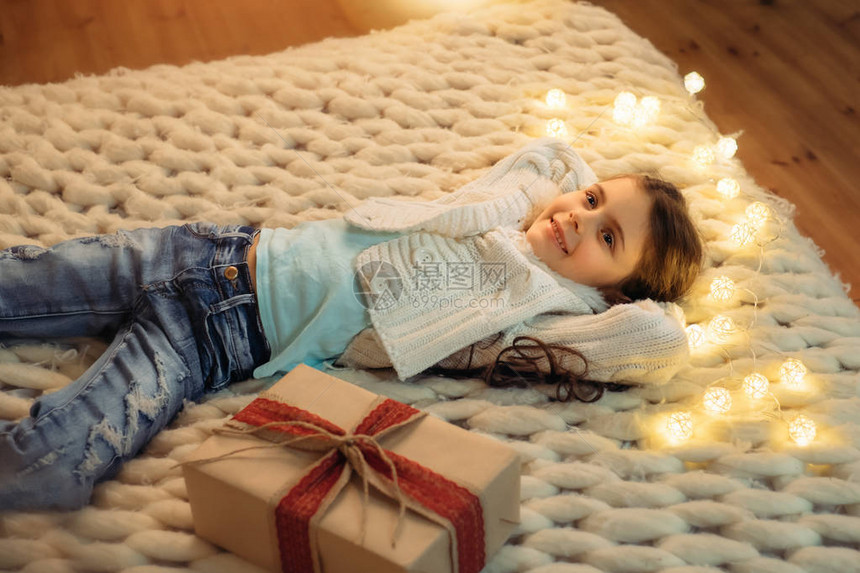 带着圣诞礼物躺在床上的快乐孩子舒适的场图片