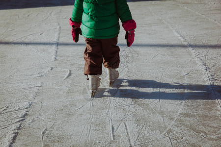 儿童脚在冬季大自然中学习在冰上滑冰图片
