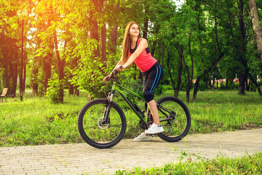 在公园里骑自行车运动快乐的女孩图片