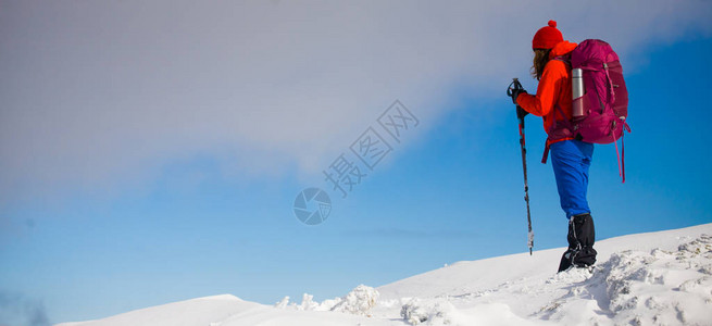 女孩背着包在山上雪行走在冬季假期图片