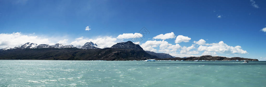 阿根廷最大的淡水湖阿根廷湖的漂浮冰山船和水晶般清澈的水背景