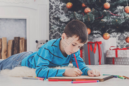 给圣诞老人写信可爱的男孩制作了圣诞礼物的愿望清单等待礼物图片