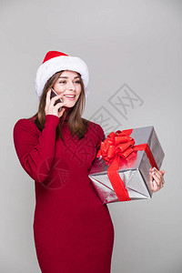 女人跟圣诞帽子讲电话拿着圣诞礼图片