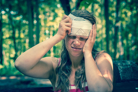 自然受伤后对头部施用压缩绷带的妇女图片