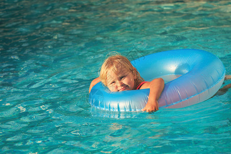 可爱的小女孩游泳与漂浮环图片
