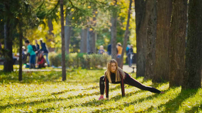 健身女子力量训练在阳光明媚的秋季公园锻炼适合锻炼身体的高加索运图片