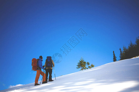 两个登山者在山上的雪坡上爬冬天爬到图片