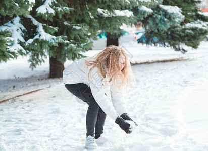 在白雪覆盖的树木背景下玩雪图片