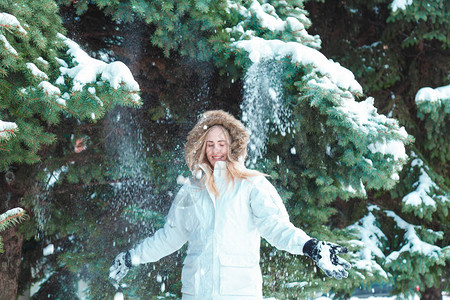 在白雪覆盖的树木背景下玩雪图片