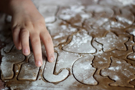 为圣诞老人烤饼干的小孩手特写图片