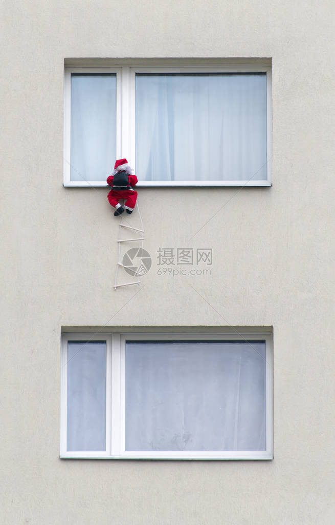 玩具圣诞老人爬在墙上图片