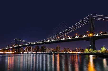 曼哈顿天际线和曼哈顿大桥在晚上与东河的倒影曼哈顿大桥是一座横跨纽约市图片