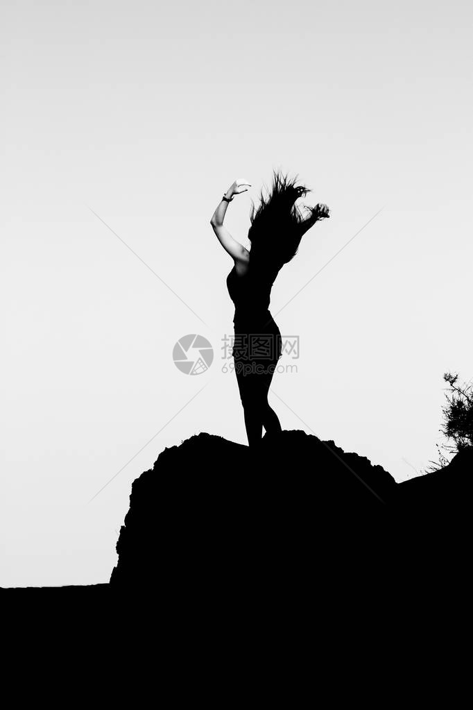 一个女孩在山顶上的剪影图片