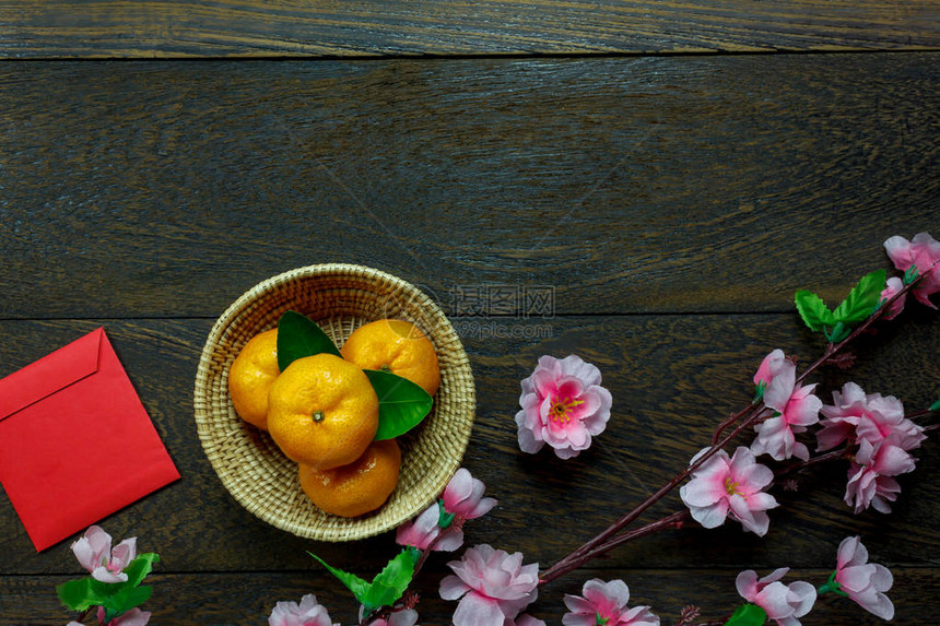 新年节日装饰品欧兰治叶子木篮红包花朵在桌边木本上图片