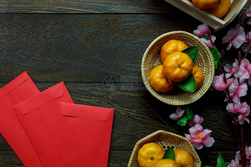 新年节日装饰品欧兰治叶子木篮红包花朵在桌边木本上图片
