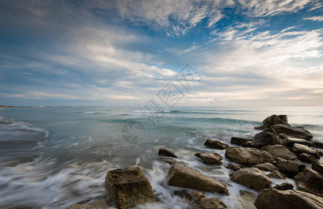 海浪流过岩石的落冰海滩背景图片