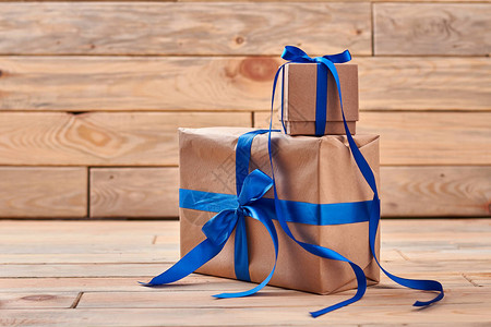 包在木头上的盒子蓝丝带的弓对礼物图片