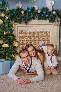 幸福的家庭坐在壁炉旁等待新年的到来图片