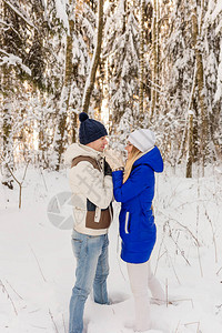 男孩和女孩在冬天的树林里休息雪地里的夫妻走在冬天公图片