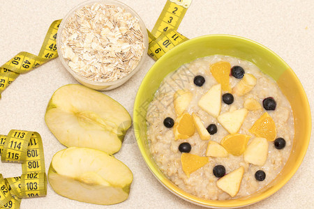早间健康营养有燕麦粥水果和计量胶带的饮食框架图片