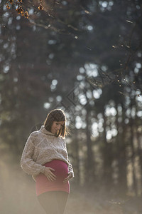 怀孕晚期的年轻女子抚摸着肿胀的腹部图片