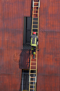 消防局长在消防站进行训练时爬上梯子图片