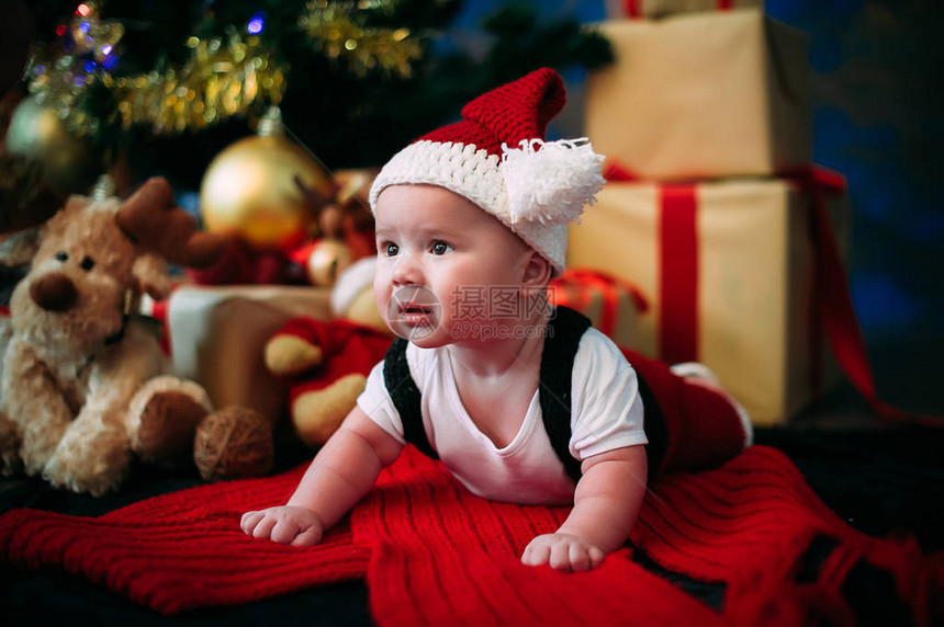 新年概念圣诞树旁边有礼物的可爱小男孩图片
