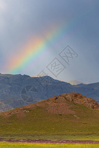 哈萨克斯坦绿色田野下的彩虹图片