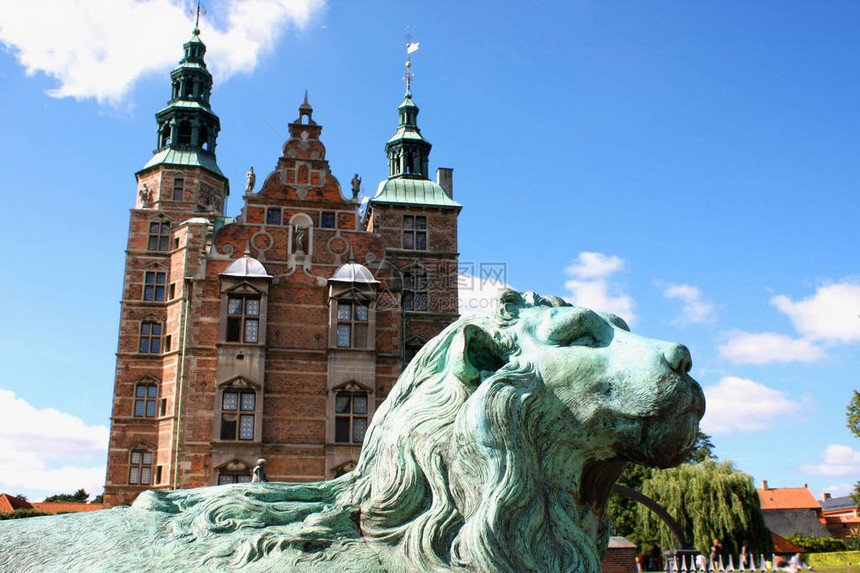丹麦哥本哈根美丽的罗森堡宫狮子雕塑反对罗森堡城和蓝天雕像位于桥前狮子若有所图片