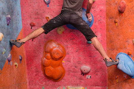 男登山者在巨石健身墙上接受培训用鞋图片
