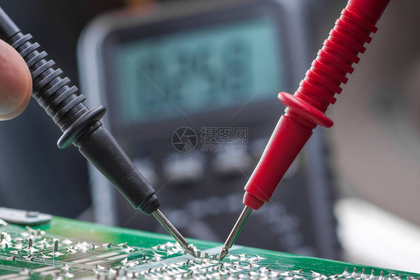 电动工程师在用多米计来检查电路板单元时图片