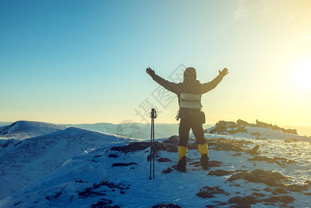 男子徒步旅行者站在山顶上庆祝成功图片