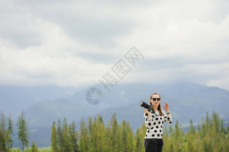 女摄影师夏天在山上拍照背景图片