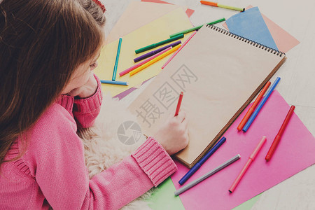 女孩用彩色标记蜡笔和铅笔绘画图片图片