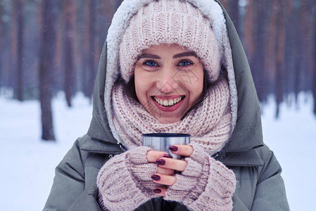 在寒冷的森林里拿着一杯茶的华丽女人的脸极端特写冬天女人喝图片