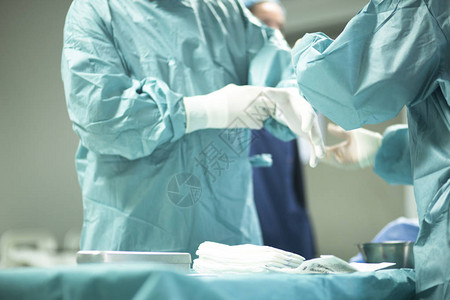 医院手术中的外科医生在手术室急诊室中穿着无菌图片
