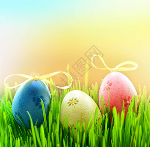 绿草上的三个彩色复活节彩蛋图片