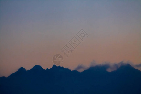 在日落时勾勒出天空的塔特拉山脉图片