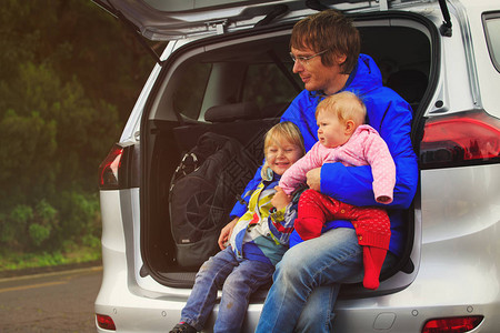 父亲和两个孩子的小孩在自然条件下乘车旅行图片