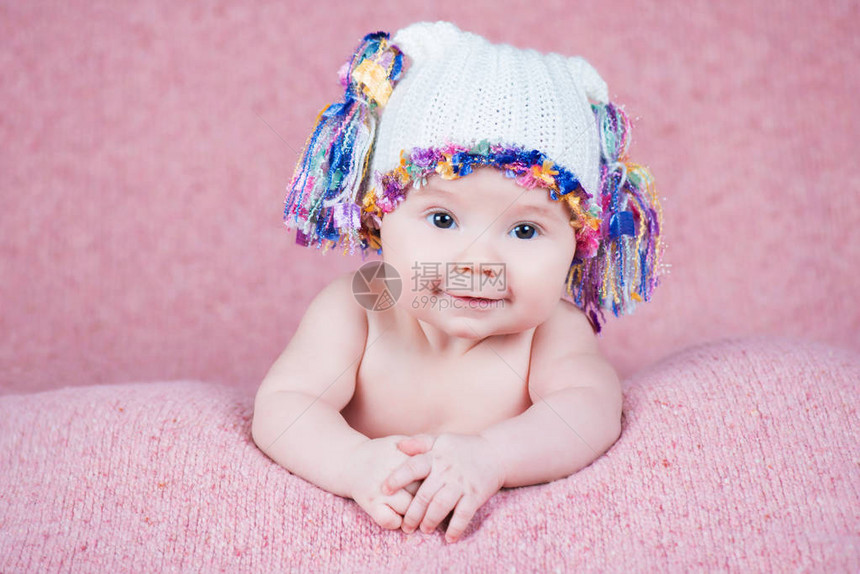漂亮的小女孩戴着粉色温暖的耳机图片
