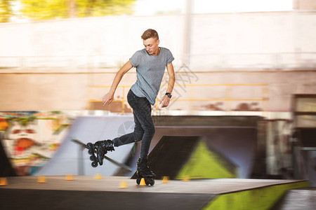 滑板场的男子滚球背景模糊的内线滑冰者图片