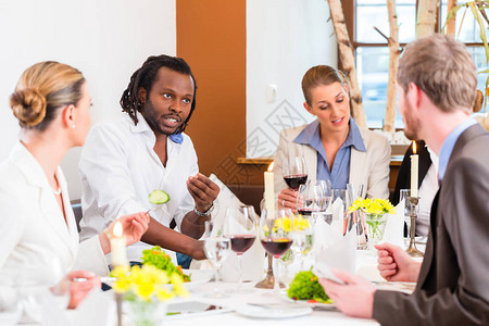 参加餐馆午餐吃饭和饮酒的男女群体在图片